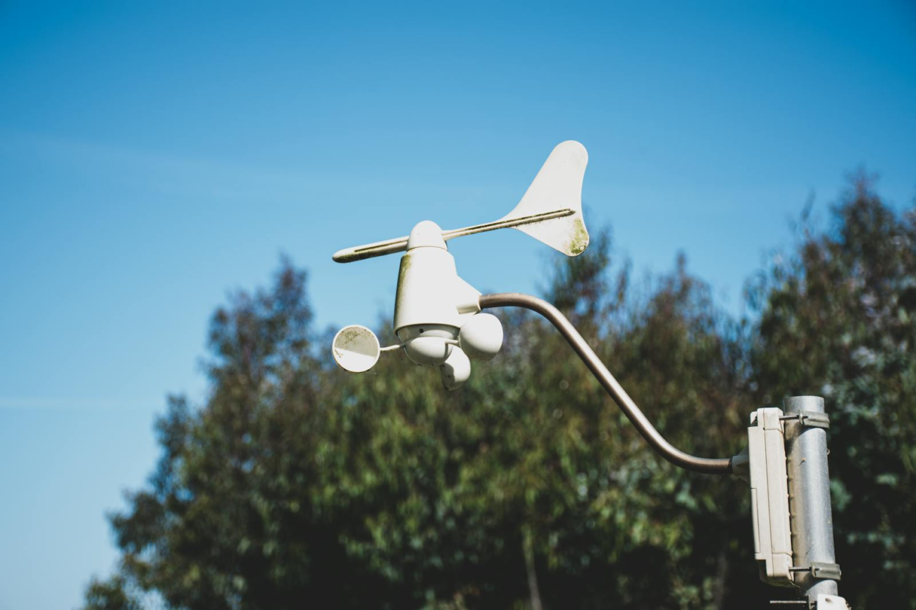 Cup anemometer and wind vane mounted outdoors measuring continuous wind speed and direction for environmental field research monitoring.