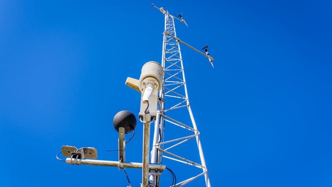 Environmental monitoring tower with sensors and instruments measuring atmospheric conditions and gas exchange above an ecosystem.