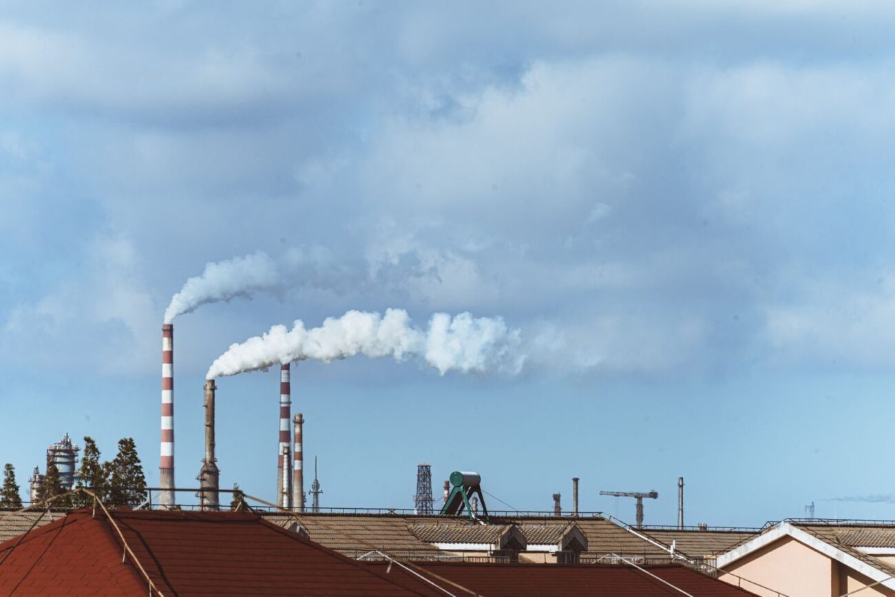 Industrial facility with chimneys releasing emissions representing the thermochemical conversion processes of incineration gasification and pyrolysis that convert biomass into energy and products with different emissions profiles