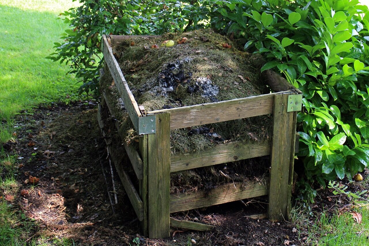 A wooden garden compost bin filled above the rim, with enough mass to build and hold internal heat