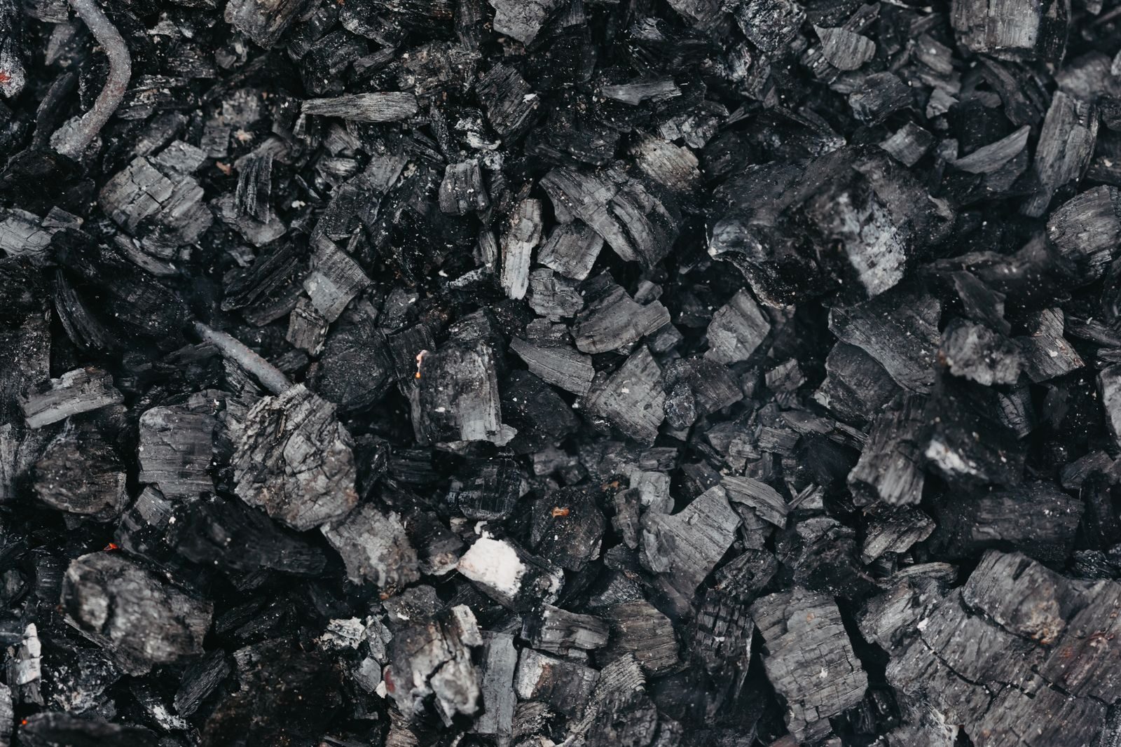 Dark biochar and charcoal material produced from slow pyrolysis of biomass showing the stable carbon rich solid that forms at lower temperatures with longer residence times and persists in soil for centuries