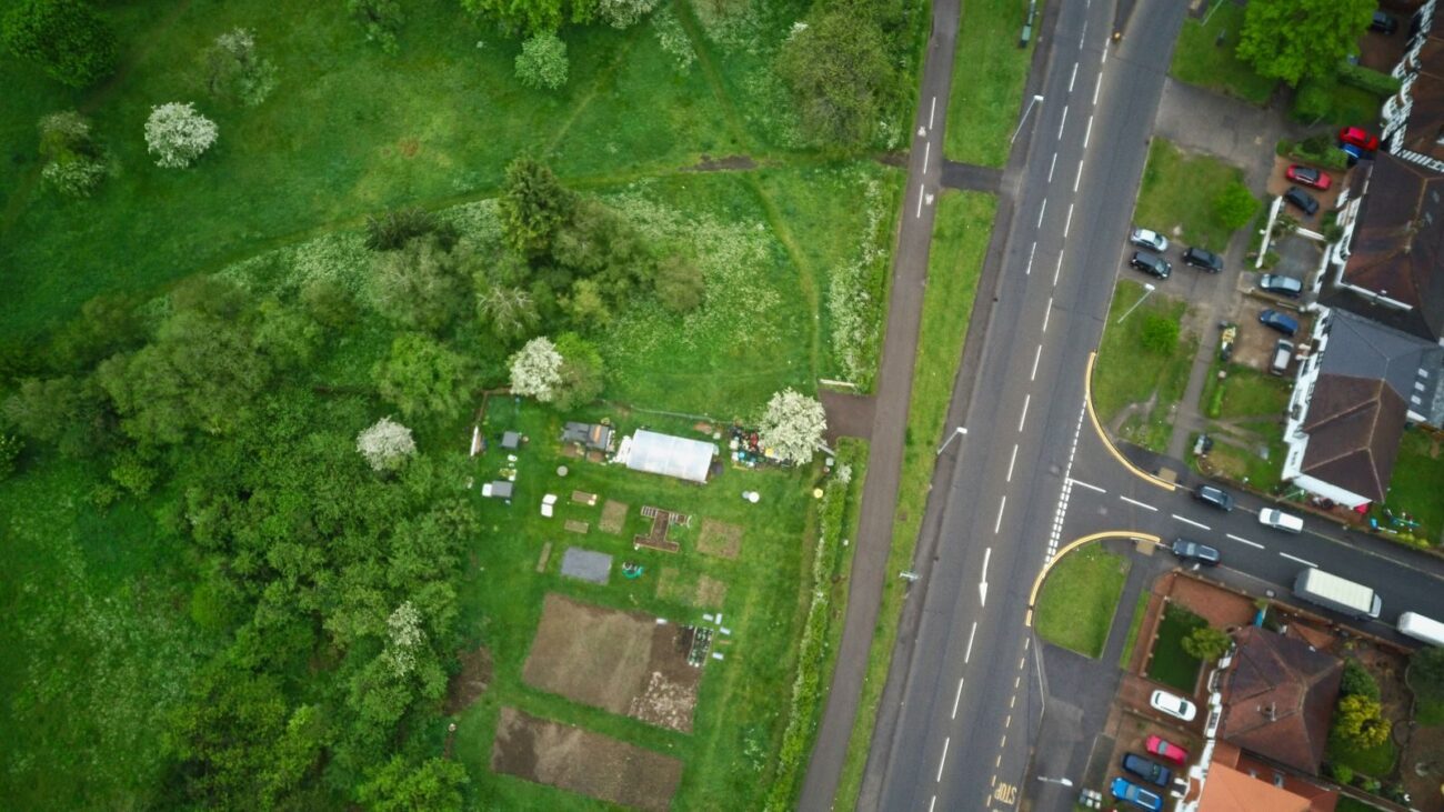 Aerial view of garden allotments next to a busy main road